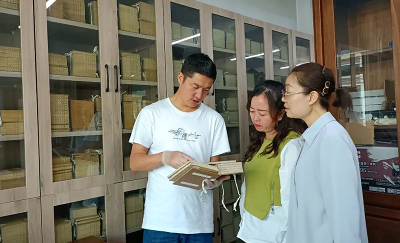 張旻（左）在大通縣圖書館了解、翻閱清代印制的經(jīng)史子集典籍