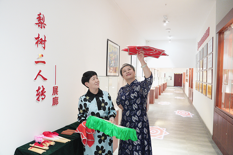 2023年6月29日，在吉林省梨樹縣地方戲曲劇團梨樹二人轉(zhuǎn)展廊，團長趙丹丹（右一）為作家龔保華講解二人轉(zhuǎn)技巧。