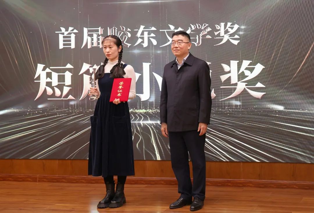 山東省作協(xié)黨組書記、副主席趙藝?。ㄓ乙唬? 為短篇小說獎(jiǎng)獲得者王銘嬋頒獎(jiǎng)