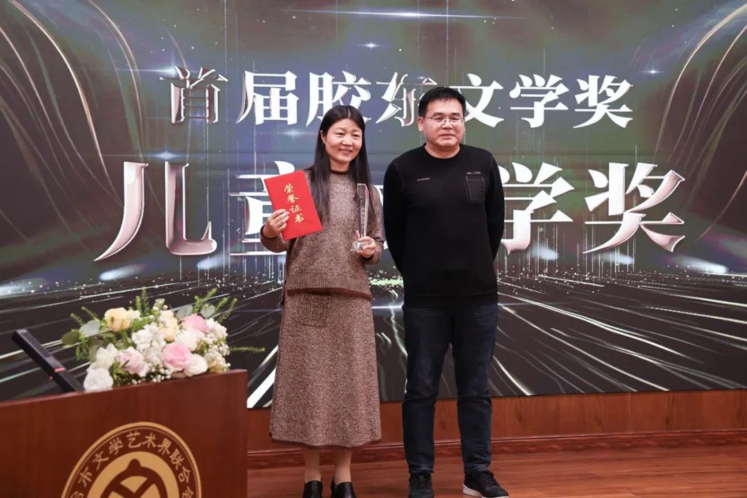 顧建平（右一）  為兒童文學(xué)獎(jiǎng)獲得者劉梅花頒獎(jiǎng)