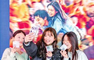 2月18日，觀眾在貴州省黔西市一家影院的電影海報前留影。 新華社發(fā)