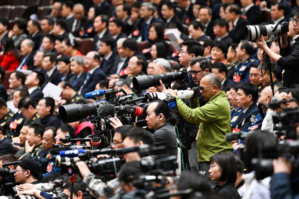 3月8日，十四屆全國人大二次會議在北京人民大會堂舉行第二次全體會議。這是記者在會議現(xiàn)場采訪。新華社記者 牟宇 攝