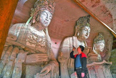 義務文保員在對重慶市大足區(qū)寶頂鎮(zhèn)香山社區(qū)的佛祖巖摩崖造像進行巡查。新華社記者 王全超攝
