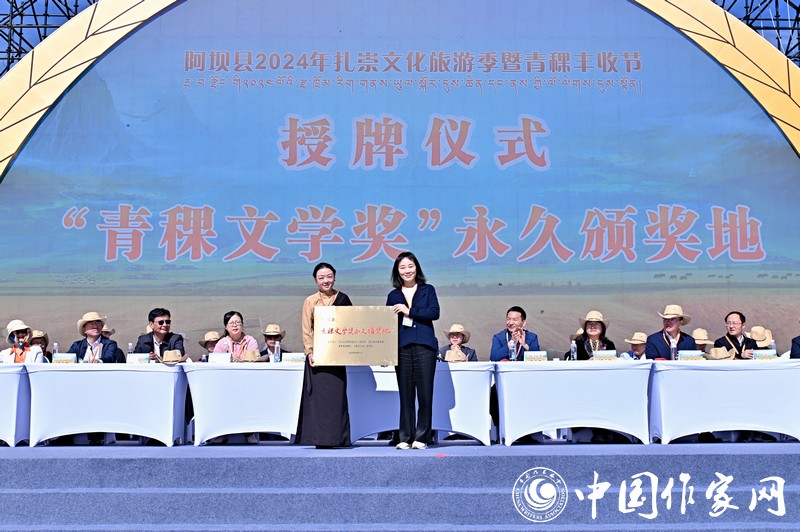 陳亞軍主編代表《民族文學(xué)》向阿壩縣授牌，紅梅部長接牌。