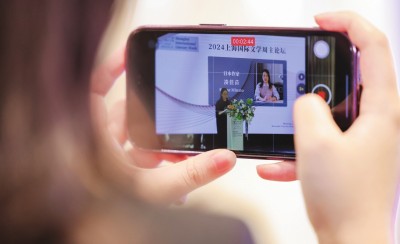 在2024上海國際文學(xué)周主論壇的會場，一位觀眾在用手機(jī)錄制日本推理小說家湊佳苗的發(fā)言。上海國際文學(xué)周供圖
